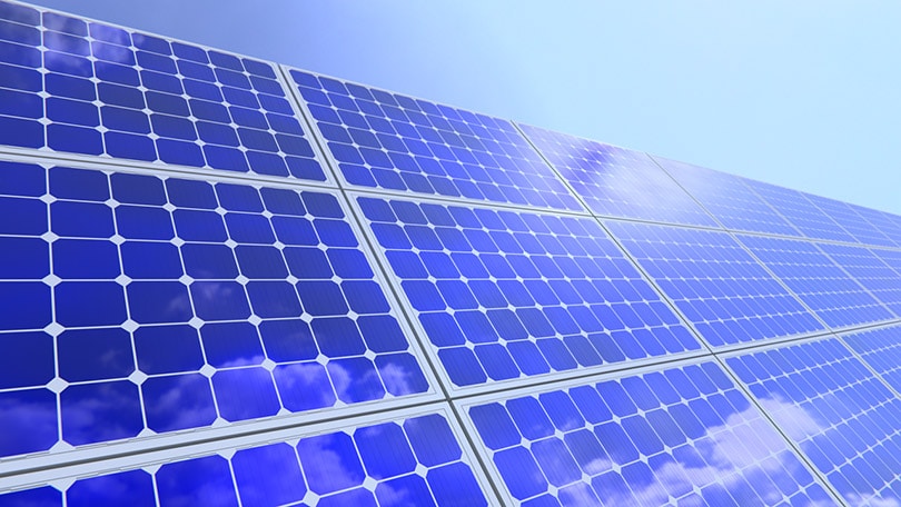 close up of solar panels reflecting the clouds