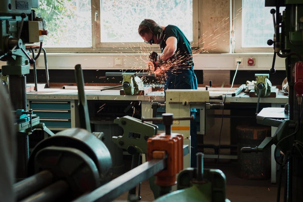 photo of a man cutting a metal with sparks