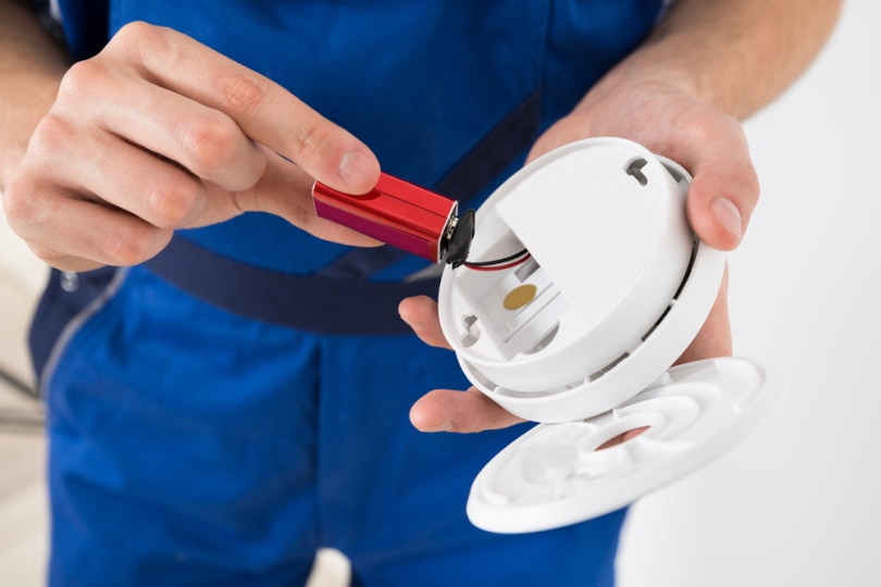 man replacing smoke alarm battery