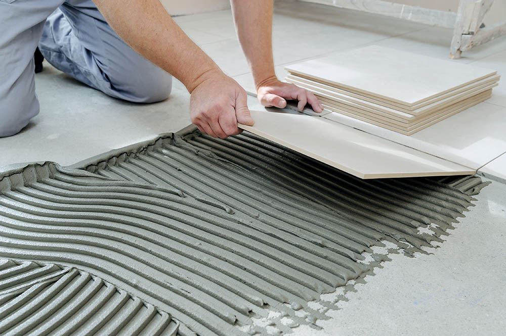 person installing rectified tile