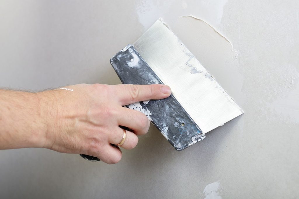 person-using-drywall-knife_Tuzemka_Shutterstock