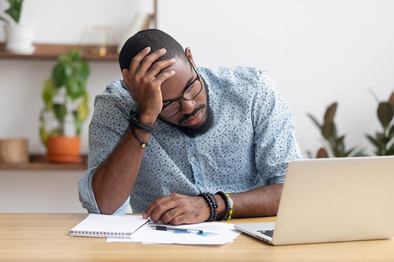 Tired depressed bored african businessman frustrated by business failure bankruptcy