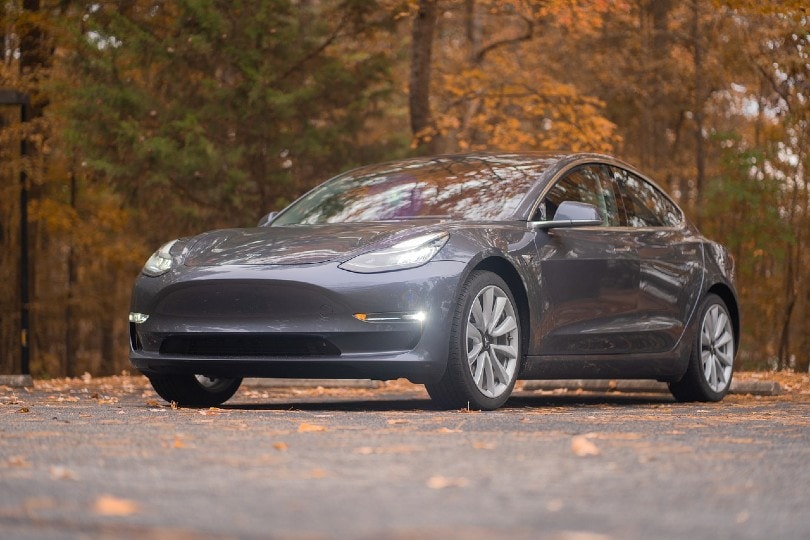 grey tesla car parked on the road