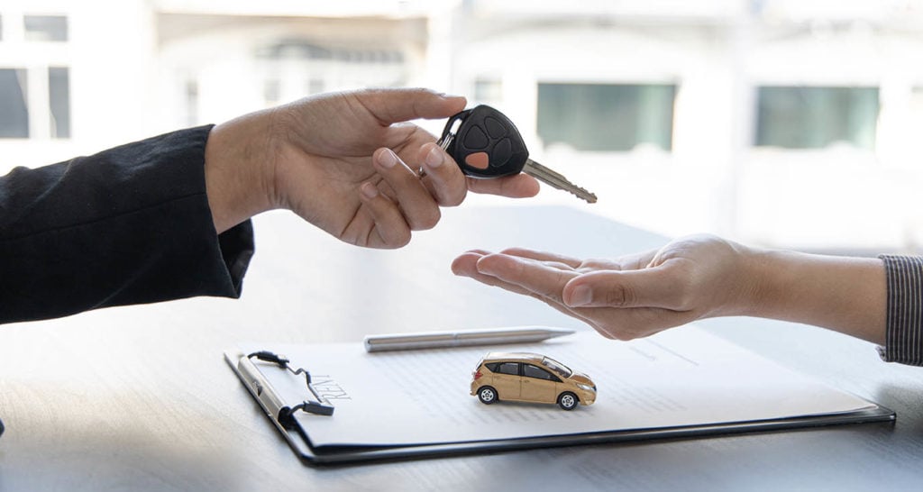 salesman giving car keys to buyer