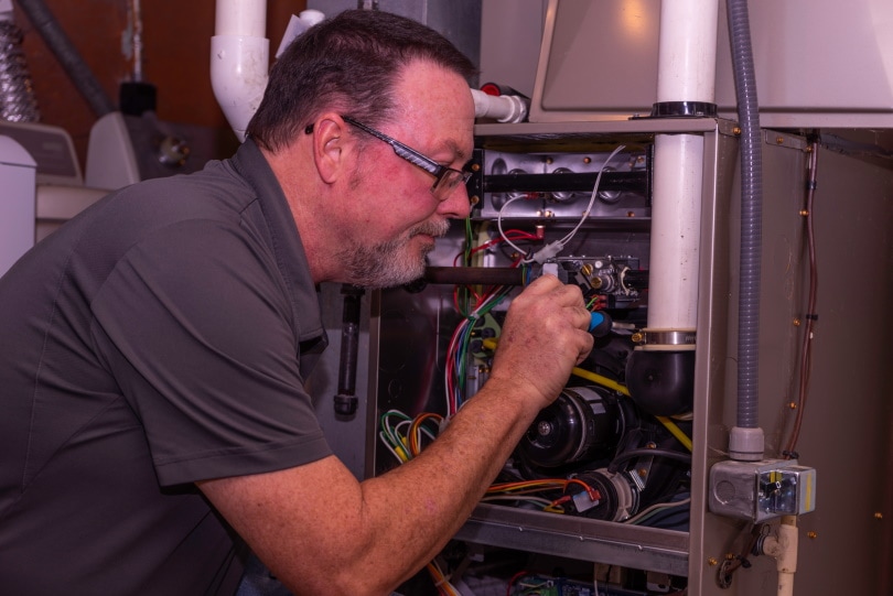 HVAC Tech Working On A Gas Furnace