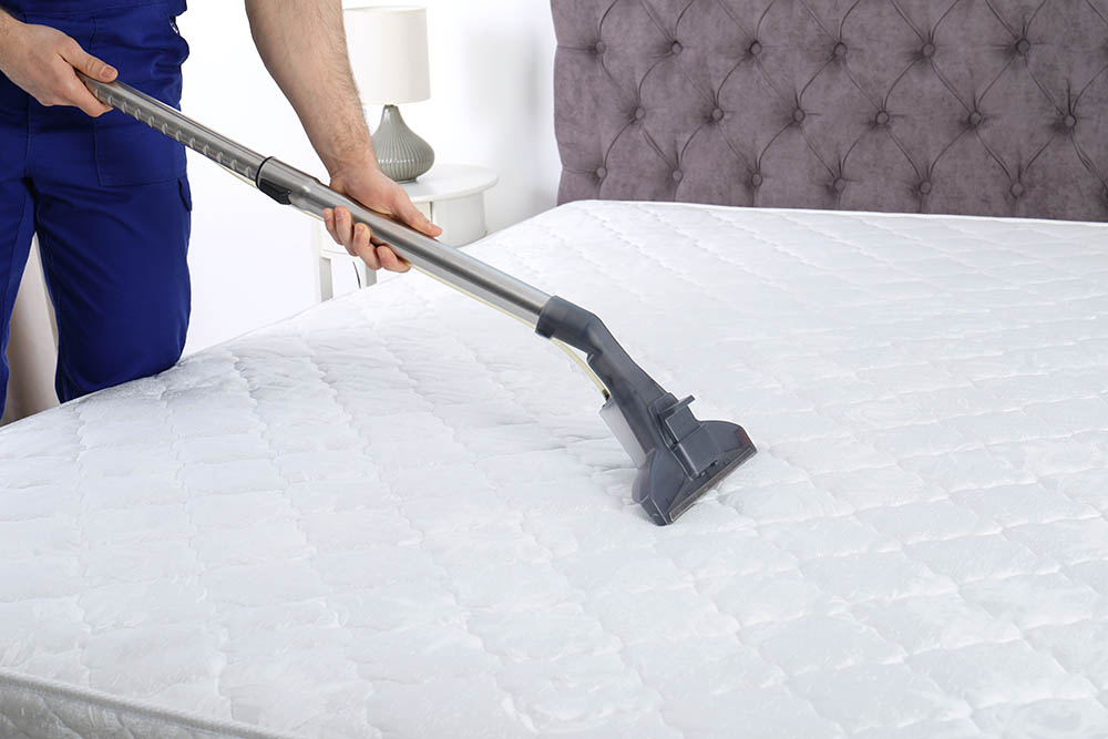 person vacuuming mattress