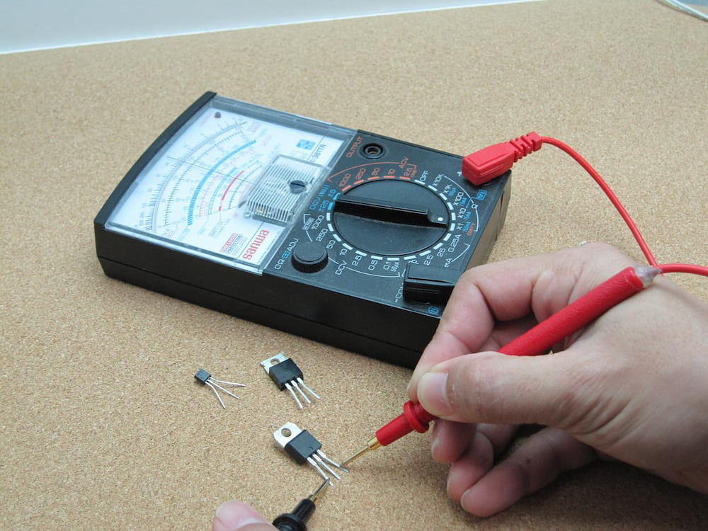 person with a multimeter on a brown surface