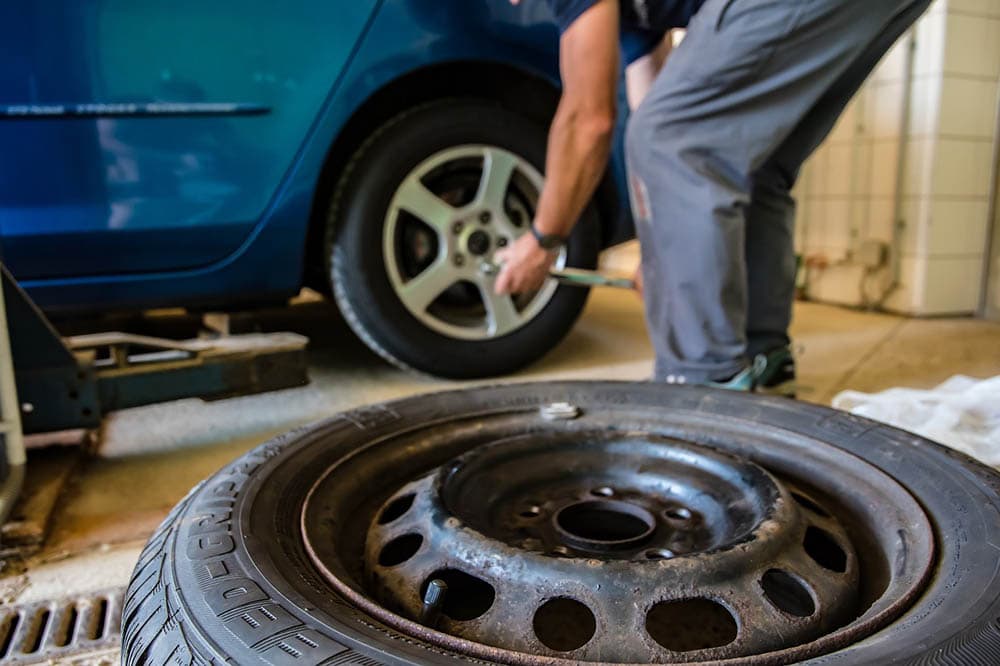 person replacing car tires