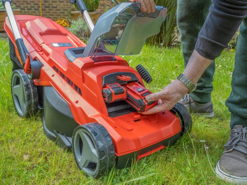 man checking lawn mower batteries