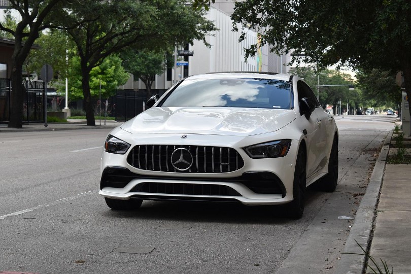 a white car parking beside a curb on the road