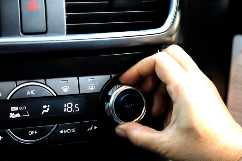 hand holding car AC button