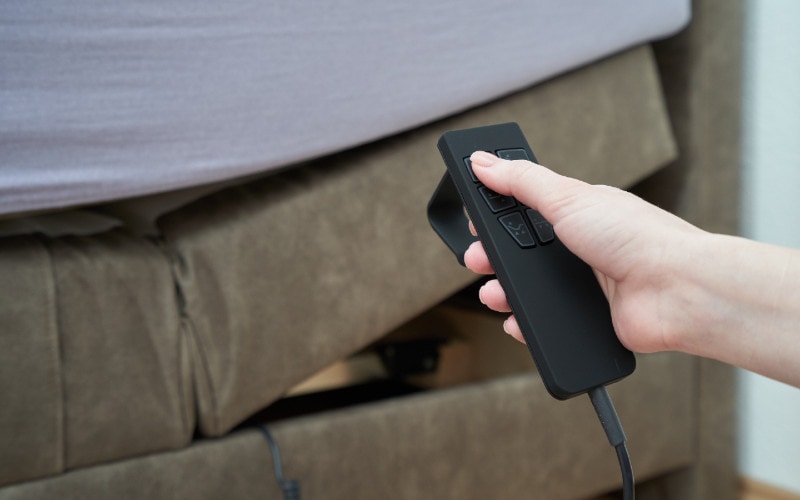 person holding a remote for an adjustable bed