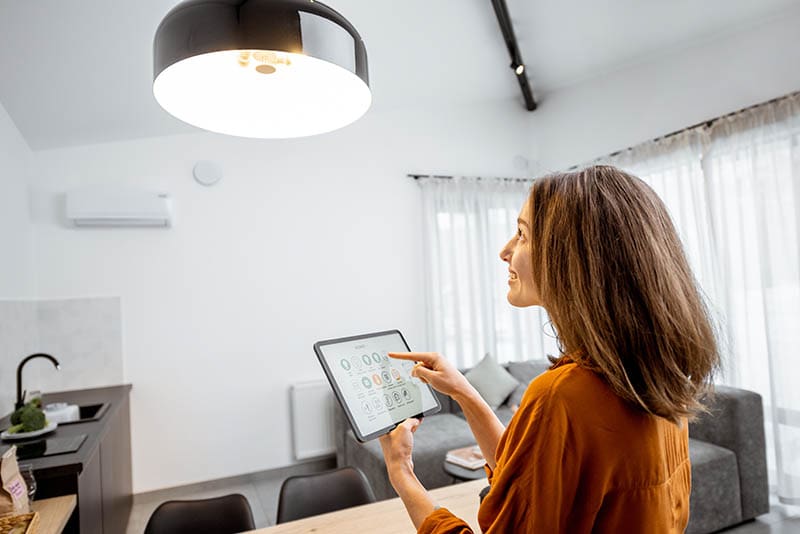 woman controlling home light with a tablet